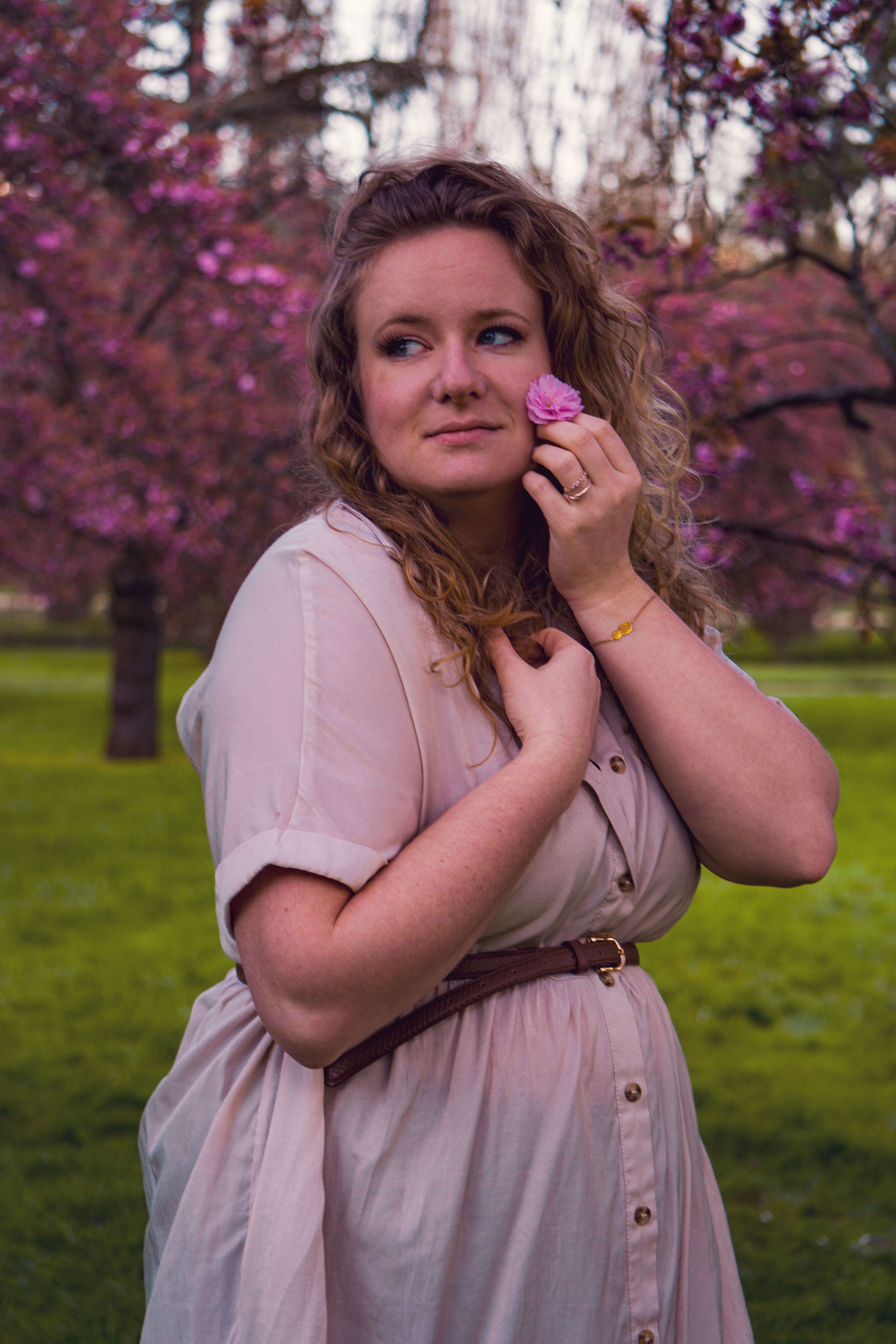 Portrait de femme en extérieur parmi les fleurs de cerisiers — photographie par Maëlle Vétois